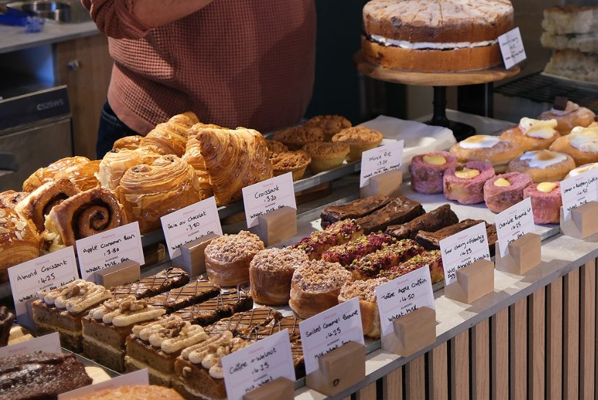 a counter full of pastries and cakes